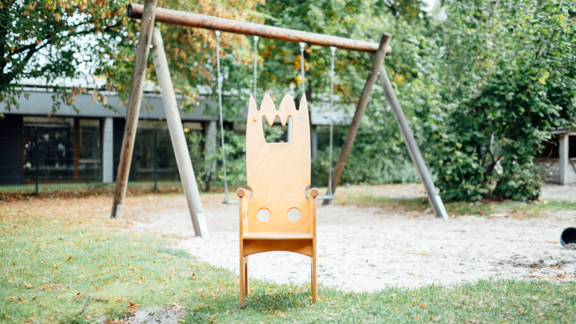 Holz-Königsstuhl steht vor Schaukel im Außengelände der Kita des Studierendenwerks Oldenburg – Kita Job