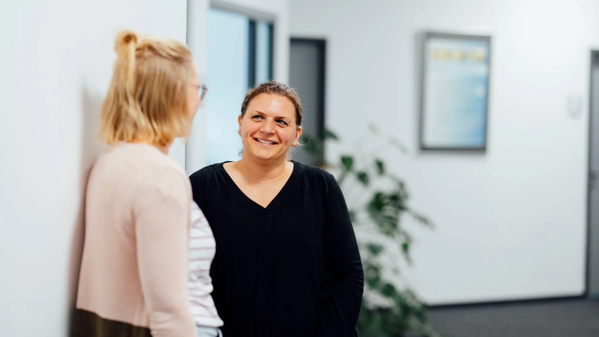 Kolleginnen führen freundliches Flurgespräch im Verwaltungsgebäude des Studierendenwerks Oldenburg – Büro & Verwaltung Job