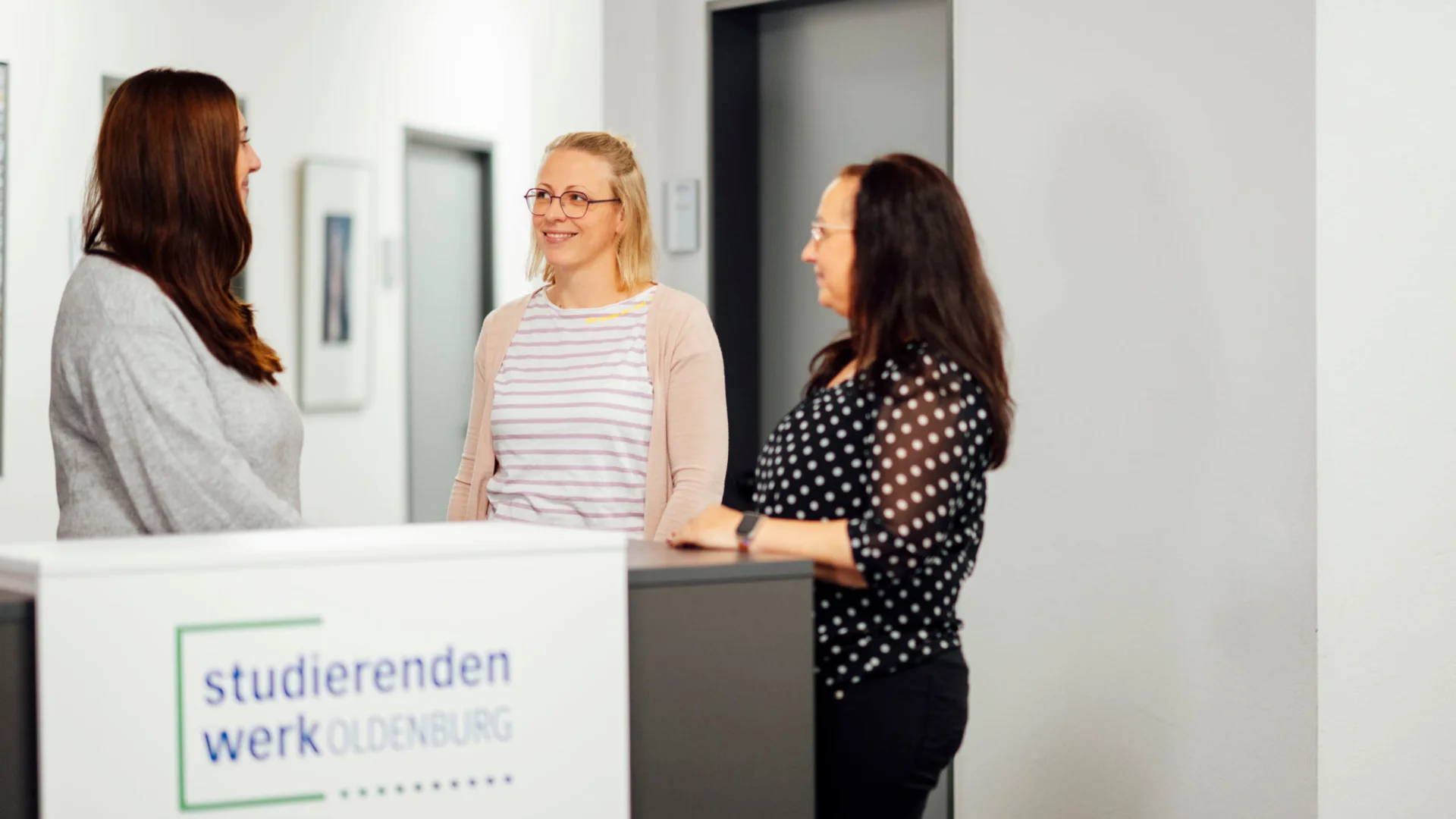 Mitarbeiterinnen sprechen am Empfangstresen des Studierendenwerks Oldenburg – Büro & Verwaltung Job