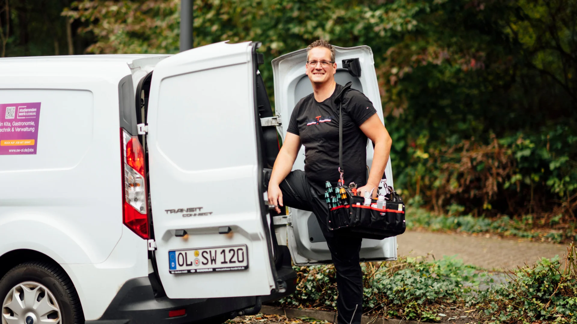 Hausmeister steigt mit Werkzeugtasche aus Service-Van des Studierendenwerks Oldenburg – Handwerk Job