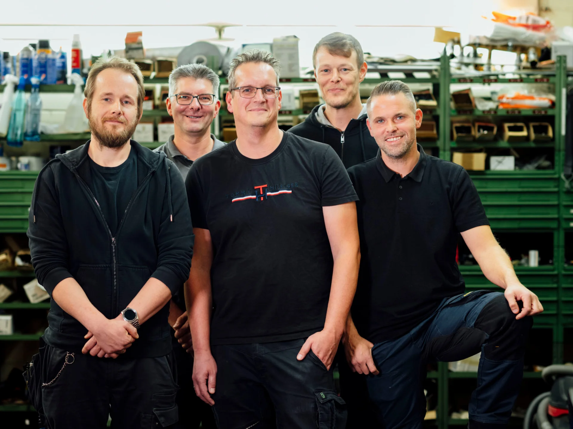 Fünf Betriebstechniker posieren lächelnd in der Werkstatt des Studierendenwerks Oldenburg – Vorteile Studierendenwerk